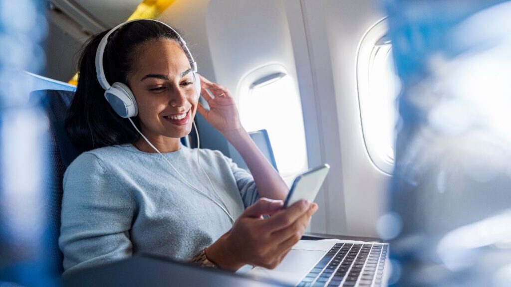 Mulher escutando música com fone de ouvido no avião