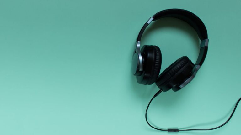 fone de ouvido preto com cancelamento de ruído em um fundo verde ciano