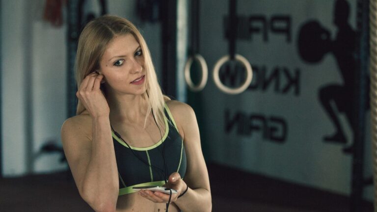 mulher com fone de ouvido na academia