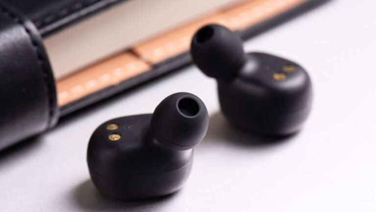 fone de ouvido bluetooth intra auricular em cima de uma mesa