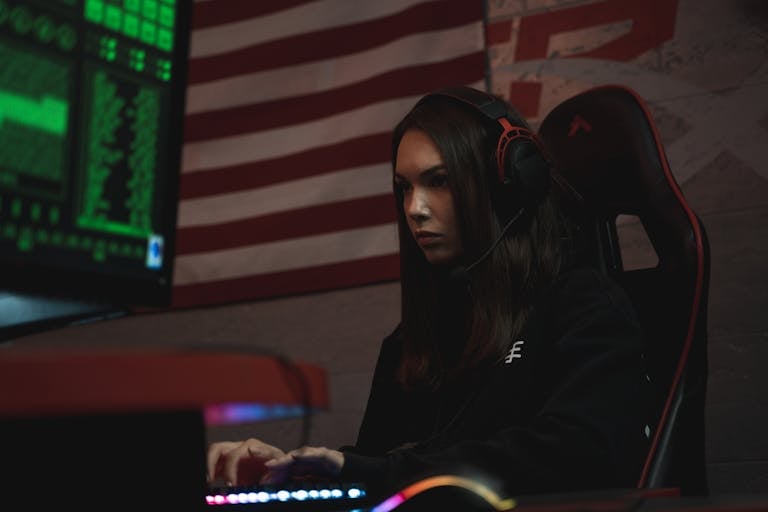 mulher com um headset gamer sentada na cadeira jogando