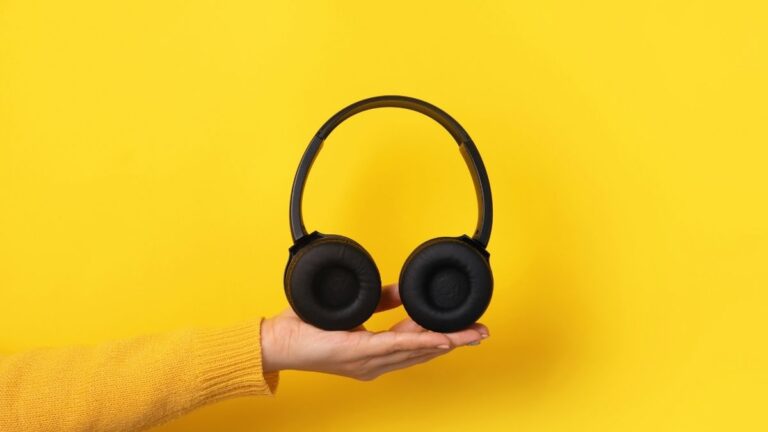 mão segurando um fone de ouvido bluetooth